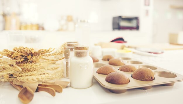 Bread in kitchen, Baking ingredients placed on wooden table, ready for cooking. Copyspace for text. Concept of food preparation, kitchen on background.