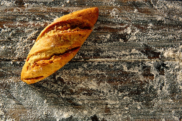 Bread loaf in a rustic wood and wheat flour