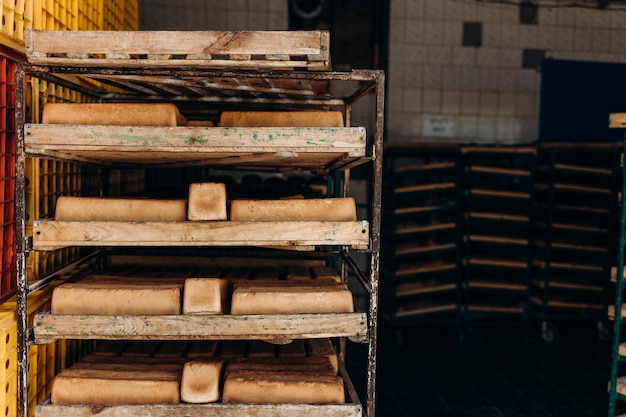 Bread loaves fresh only baked on a wooden cart rack Wooden trolley with bread for baking just pulled out of the oven a lot of white loaves of bread