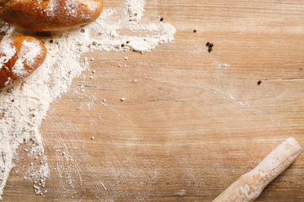 Bread and rolling pin on wooden background