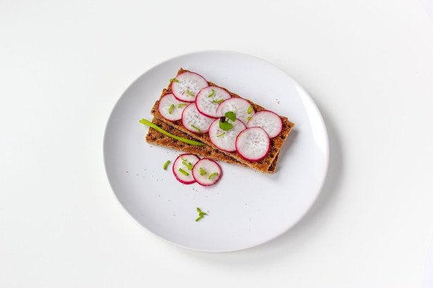 Bread rolls from crisped bread with chopped radishes and herbs Sandwich with vegetables and basil