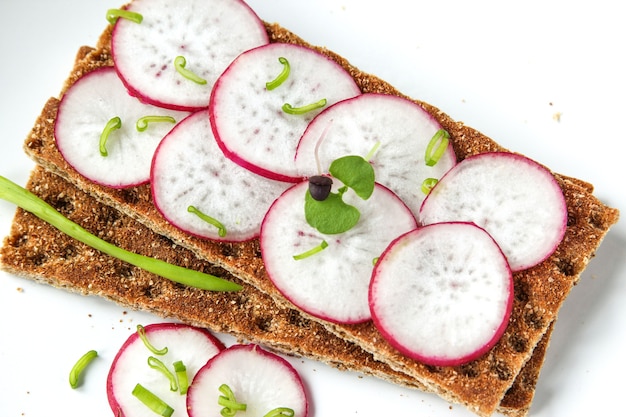 Bread rolls from crisped bread with chopped radishes and herbs Sandwich with vegetables and basil