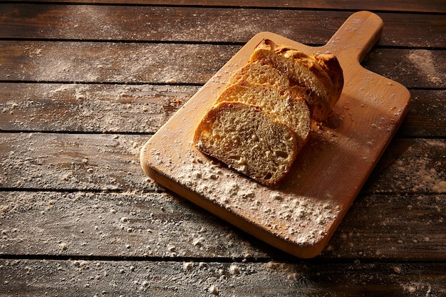 Bread sliced loaf on wooden board in rustic wood