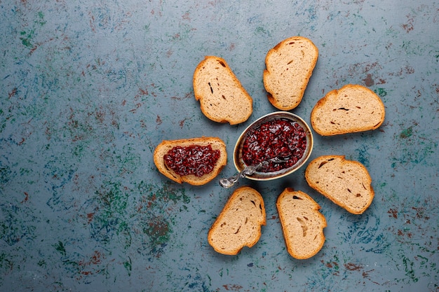 Fette di pane con marmellata di lamponi, spuntino sano facile, vista dall'alto