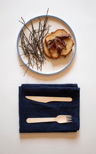 Bread small sticks with brown flowers and a wooden fork and knife on top flat lay