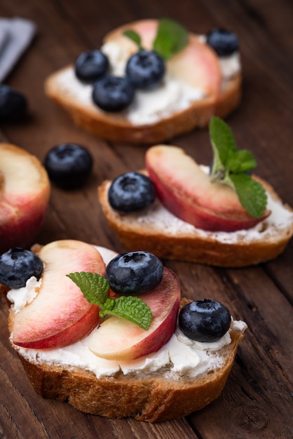 Bread toast with peach and blue berry on wood