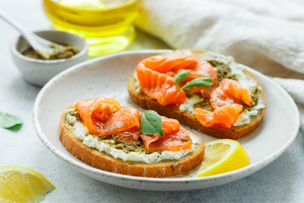 Bread toast with salted salmon, pesto sauce, lemon and cream cheese (ricotta)