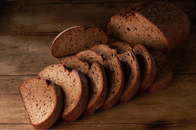 Pane tradizionale pane fatto in casa tagliato a fette su un fondo di legno rustico primo piano