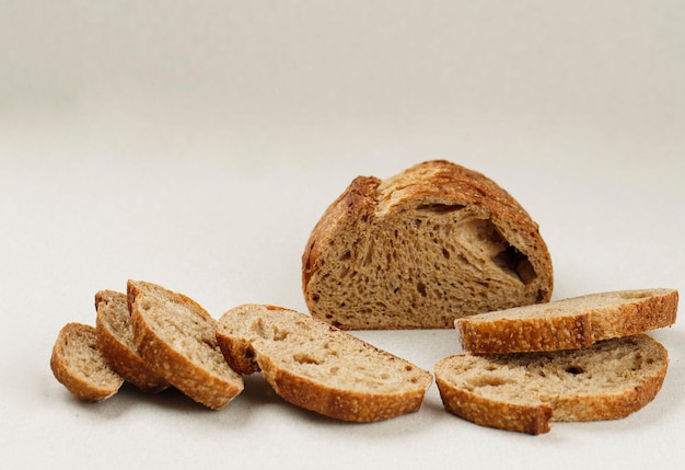 Pane pane a lievitazione naturale tradizionale tagliato a fette su uno sfondo color crema