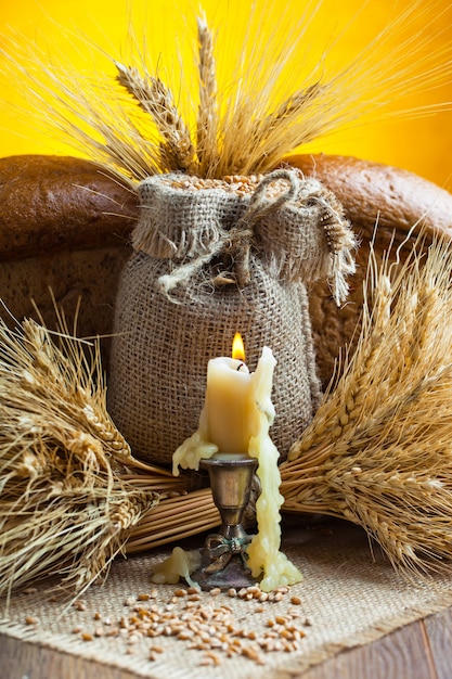 Bread and wheat grains on a wooden background