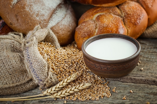 Bread and wheat grains on a wooden background