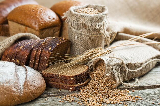 Bread and wheat grains on a wooden background