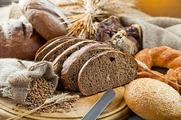 Bread and wheat grains on a wooden background