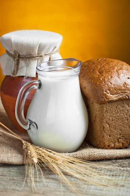 Bread and wheat with jug of milk