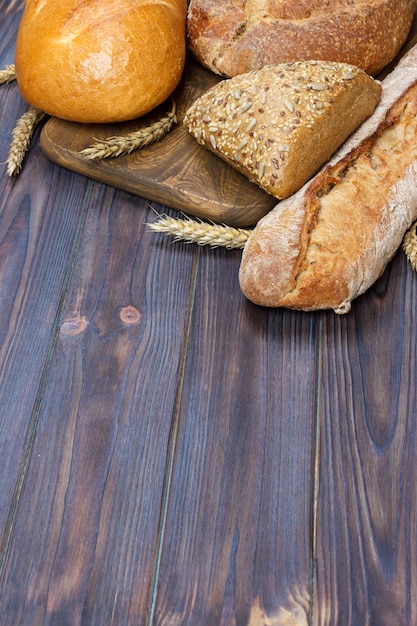 Bread and wheat on wooden background. top view with copy space