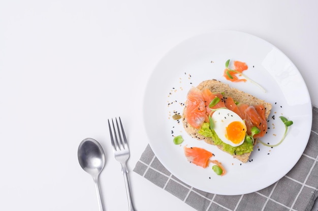 Bread with avocado vegetables fruit and egg on white background Healthy breakfast concept