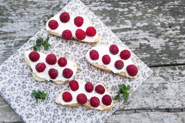 Bread with curd cheese and fresh raspberries.