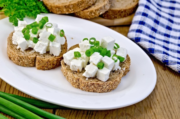 Bread with feta cheese and green onions on a board