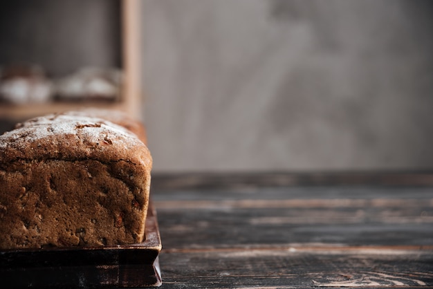 Pane con farina sulla tavola di legno scura