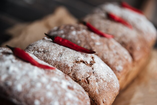 Bread with flour and pepper on dark wooden table