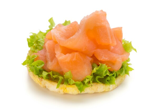 Bread with fresh salmon fillet isolated on white surface, top view.