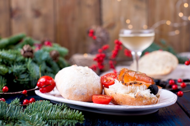 bread with rice and red fish, a glass of white wine and a Christmas tree