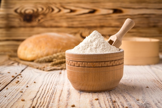 写真 木製のテーブルに小麦粉のスパイクと穀物とパン農業と収穫の概念