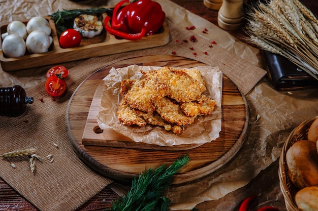 Breaded chicken fillet on the kitchen table Top view