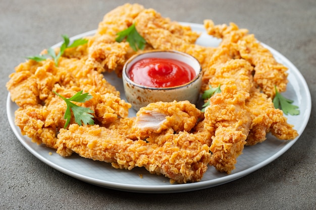 Breaded chicken strips with sauces.