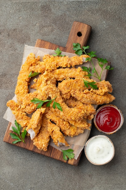 Breaded chicken strips with two kinds of sauces.