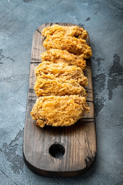 Photo breaded chicken wings cuts on grey background