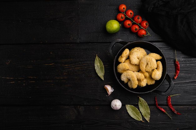 Breaded Deep Fried shrimps set, on black wooden table background, top view flat lay, with copy space for text