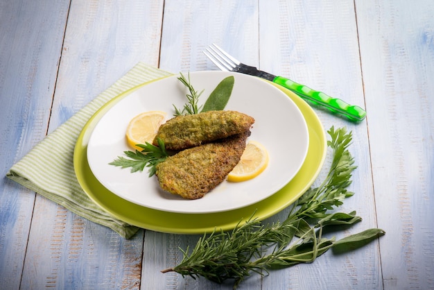 Photo breaded fish with aromatic herbs