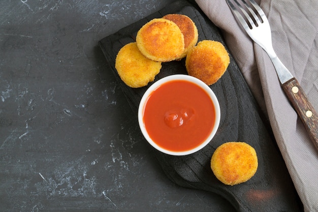 Photo breaded fried potato balls with tomato sauce