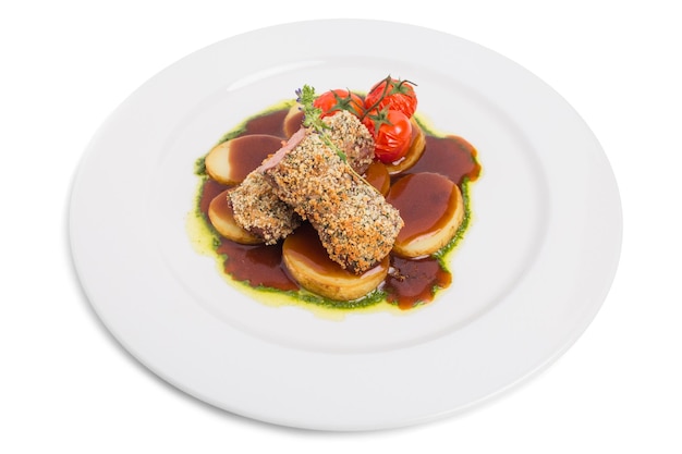 Photo breaded pork fillet with baked potatoes and tomatoes confit isolated on a white background