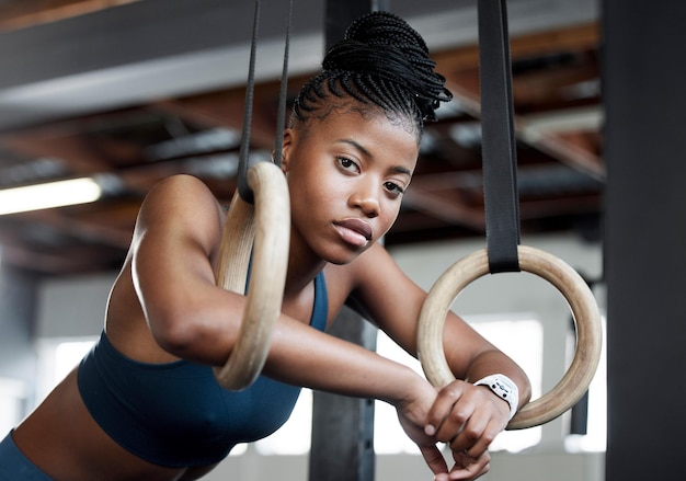 Брейк-гимнастика и портрет чернокожей женщины с кольцами для тренировки мышц и рук в спортзале Фокус сильный и лицо африканской гимнастки с выступлением во время тренировки или упражнения в клубе