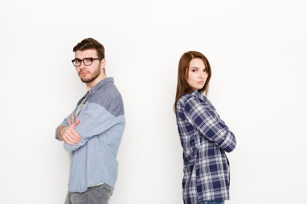 Rompere, divorziare. sconvolto giovane coppia in piedi di schiena dopo il litigio, isolato sfondo bianco, copia spazio