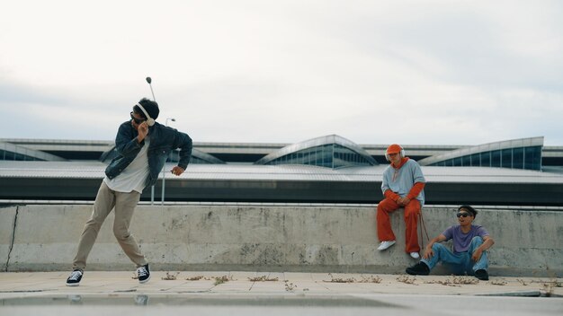 Foto breakdancer geniet van het uitvoeren van freestyle bewegingen met vriend cheering sprightly