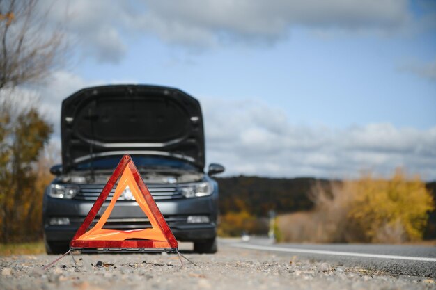 Photo breakdown triangle stands near a broken car