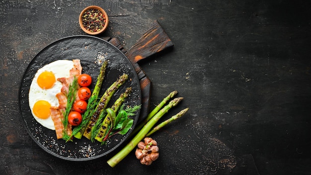 Breakfast Asparagus eggs bacon and cherry tomatoes Healthy food Top view Free space for your text