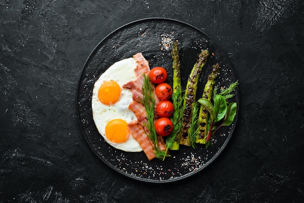 Breakfast Asparagus eggs bacon and cherry tomatoes Healthy food Top view Free space for your text