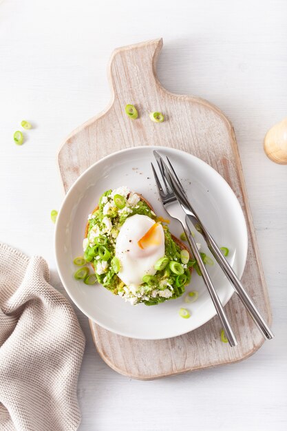 Breakfast avocado sandwich with poached egg and feta cheese