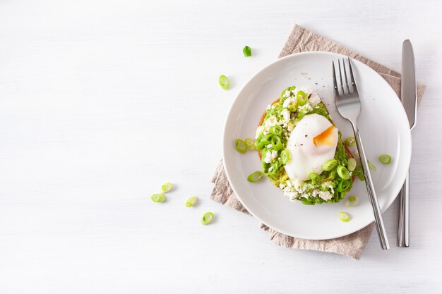 Breakfast avocado sandwich with poached egg and feta cheese