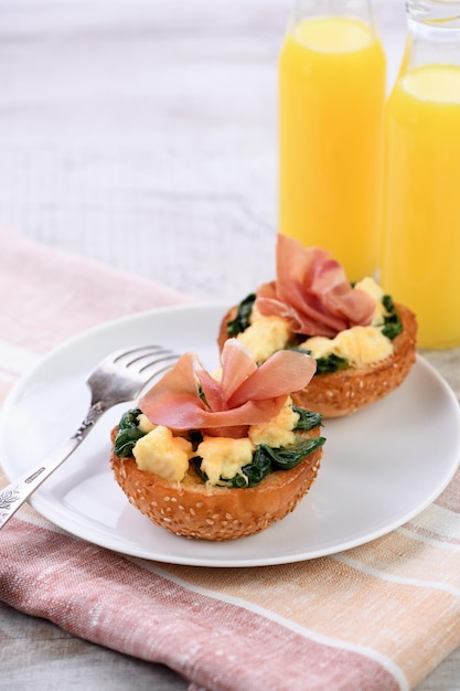 Breakfast. Baked bun with cheese, spinach, prosciutto and orange juice