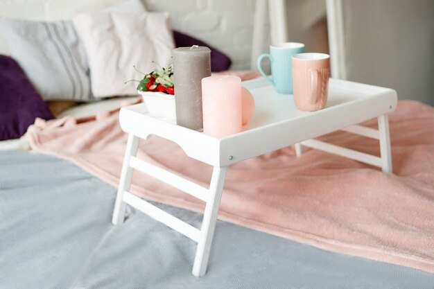 Breakfast in bed. Modern bedroom in pastel colors.