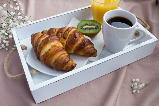 Breakfast in the bed on the white wooden tray
