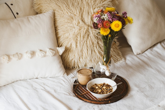 Breakfast in bed with bouquet of flowers