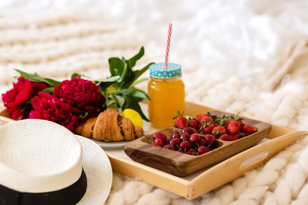 Breakfast in bed with coffee, croissants, strawberries and juice