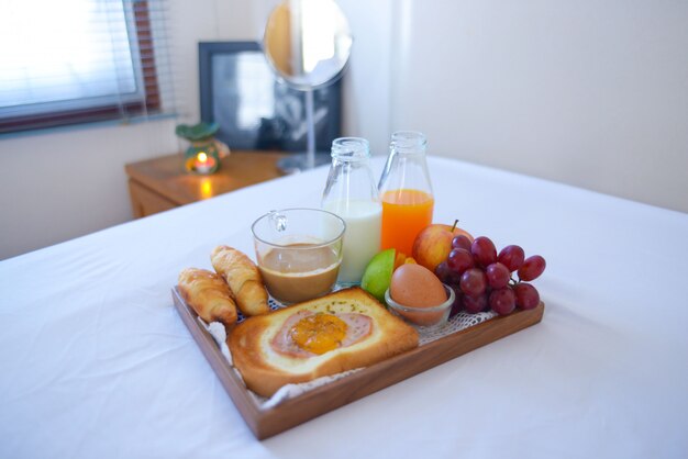 Breakfast on bed with coffee, croissants Window light