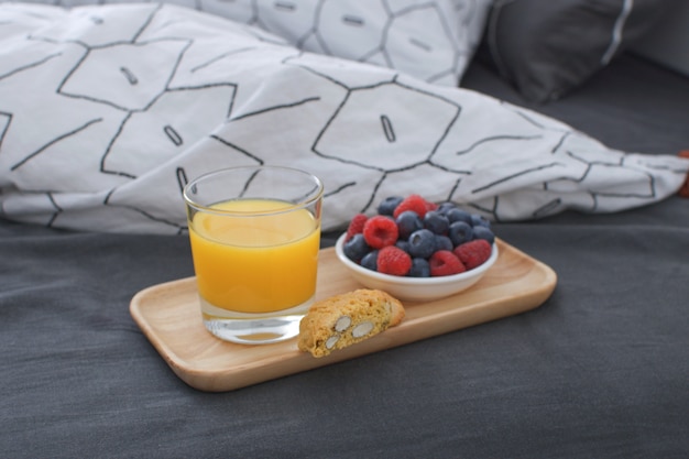 아침 식사 침대 나무 트레이 이른 아침 인테리어 기하학적 시트와 베개 케이스 딸기 오렌지 주스 비스킷
